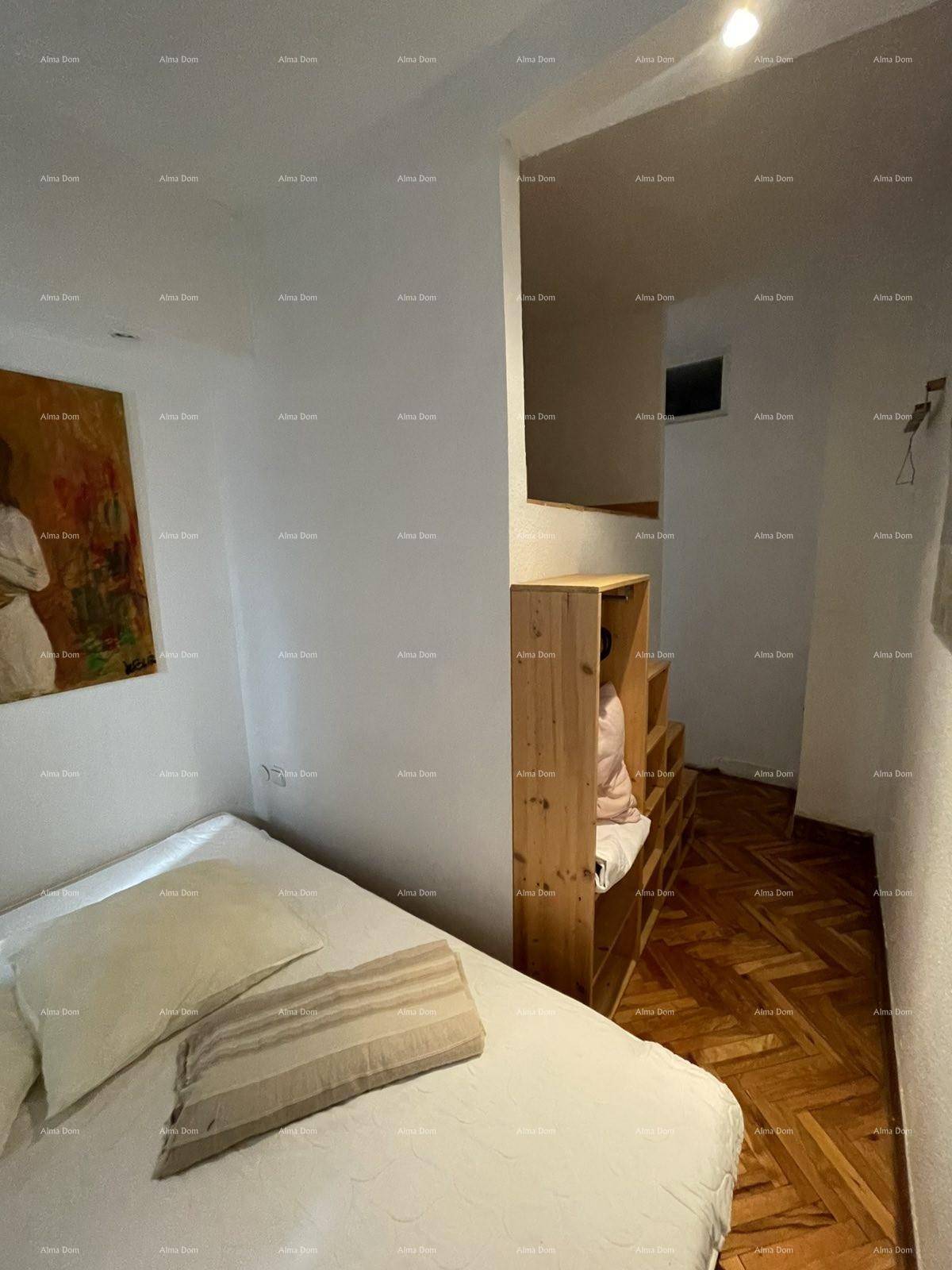 Schlafzimmer mit Holzboden und einfacher Einrichtung, mit Blick auf einen erhöhten Bereich.