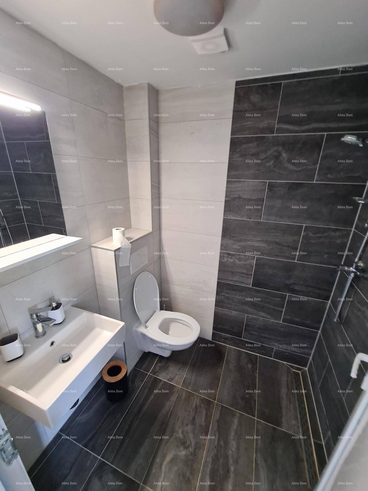 Modernes Badezimmer mit dunklen und hellen Fliesen, Dusche und wandhängendem WC.