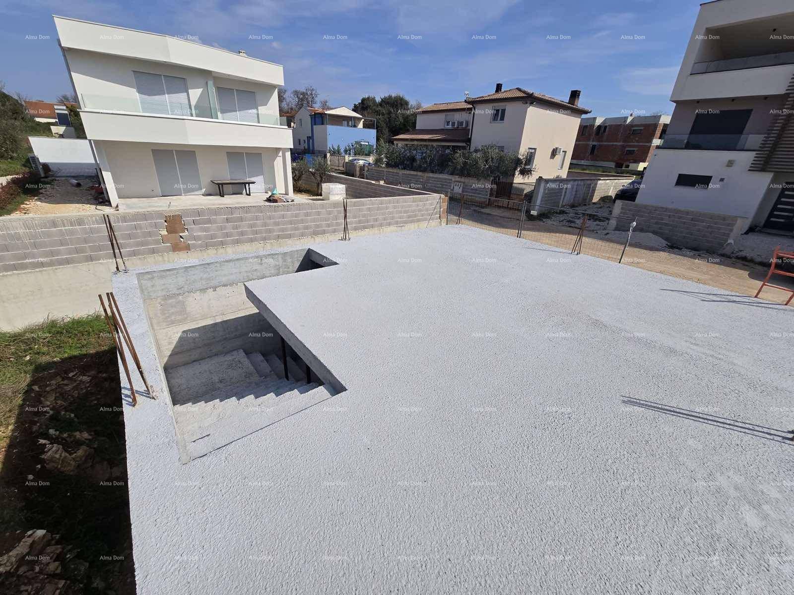 Betonierte Fläche einer Baustelle mit Treppenabgang und umliegenden modernen Wohnhäusern.