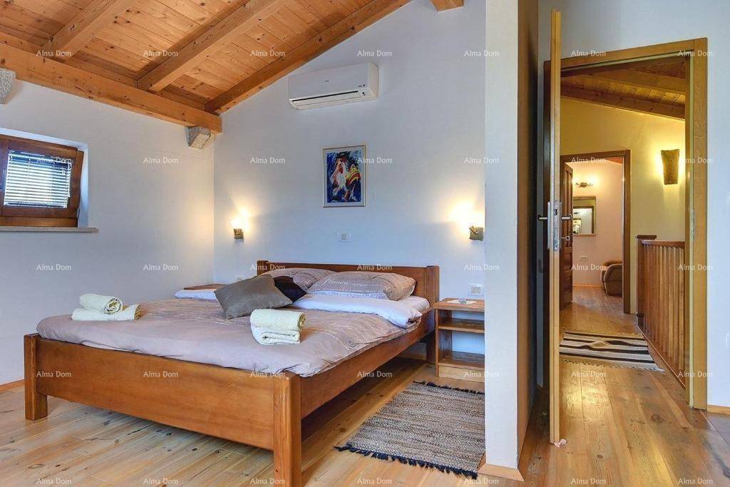 Schlafzimmer mit Holzbalkendecke, Klimaanlage und Zugang zu einem Flur.