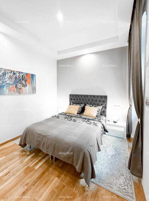 Elegantes Schlafzimmer mit grauem Bett und Holzboden, akzentuiert durch Kunstwerke.