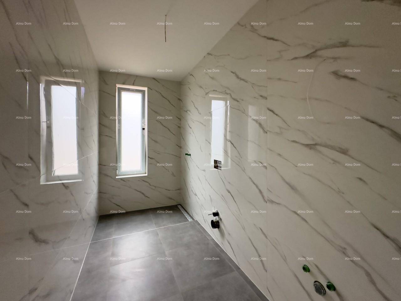 Badezimmer im Rohbau mit eleganten Marmorfliesen und schmalen Fenstern, viel Potenzial.