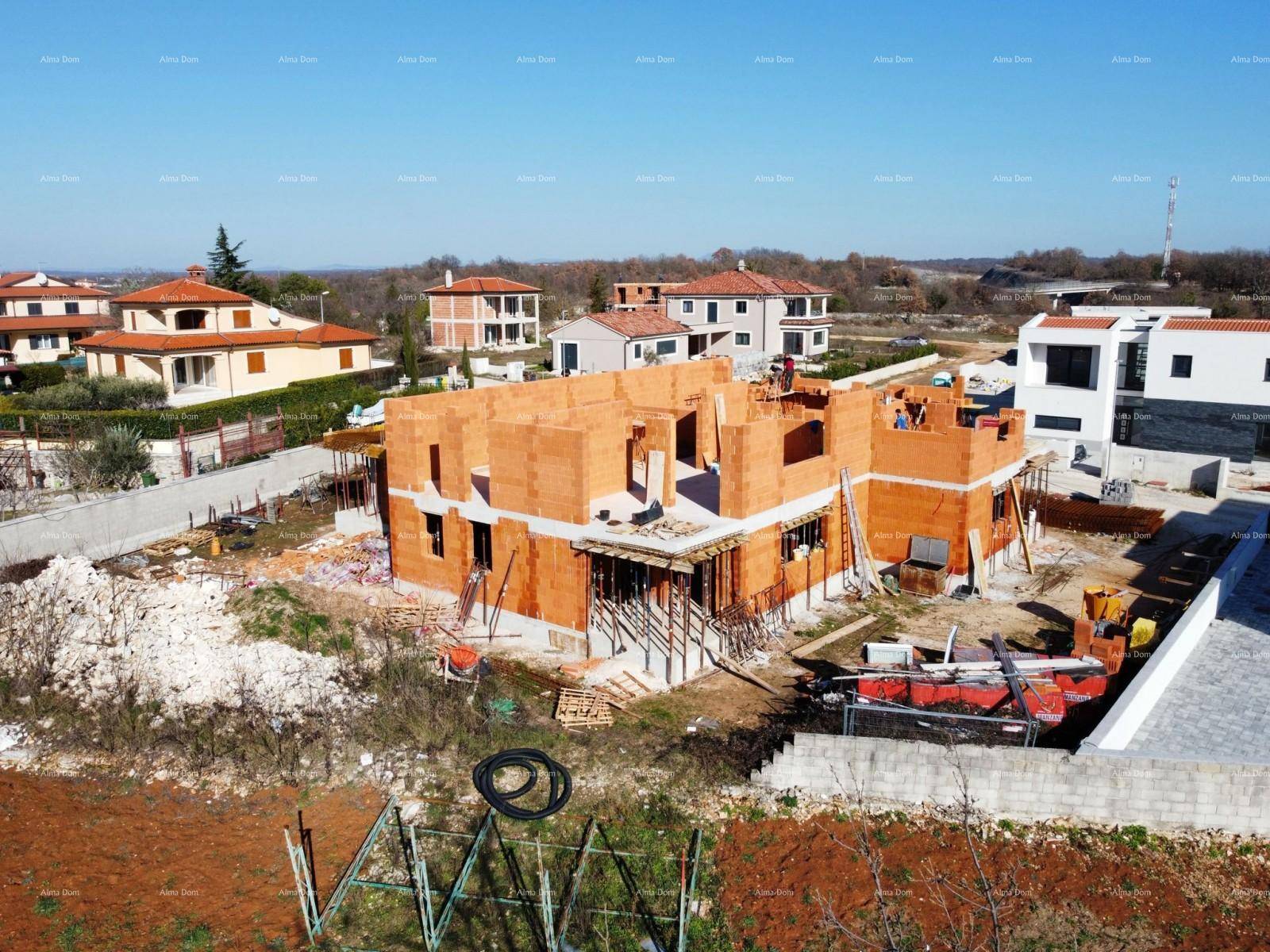 Luftaufnahme einer Baustelle mit Rohbauten und Blick auf die umliegende ländliche Bebauung.