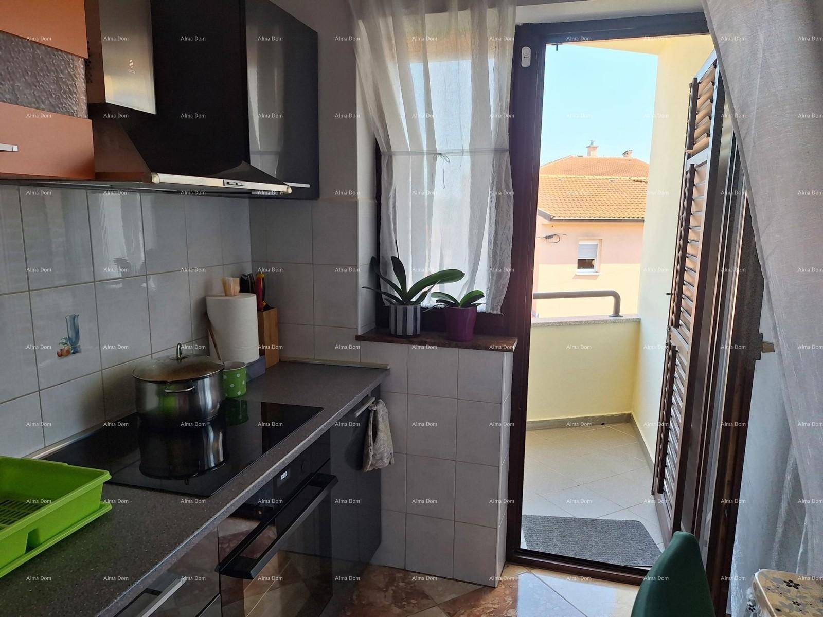 Küchenzeile mit Kochfeld und Zugang zu einem kleinen Balkon.