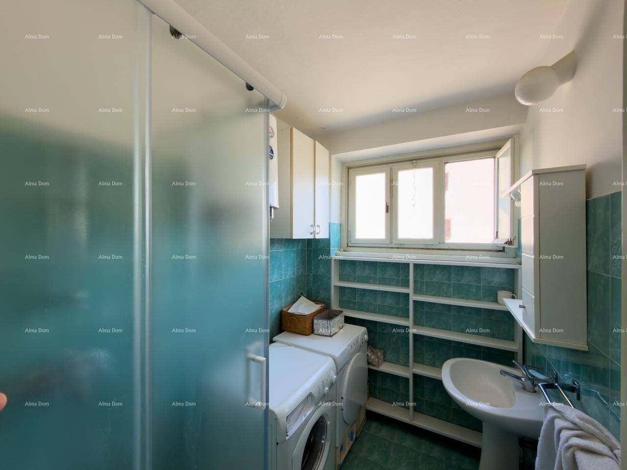 Badezimmer mit Duschkabine, Waschbecken, Waschmaschine und Fenster.