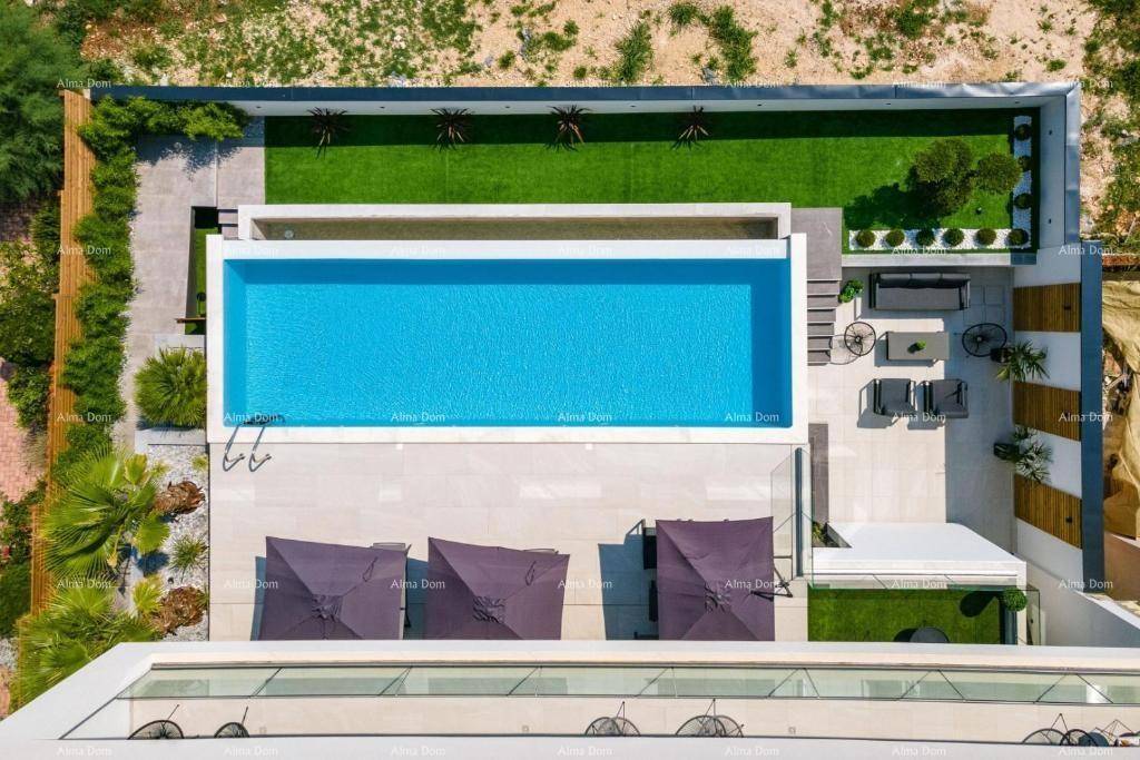 Luftaufnahme der modernen Villa mit großem Pool, Liegebereich und gepflegtem Garten.
