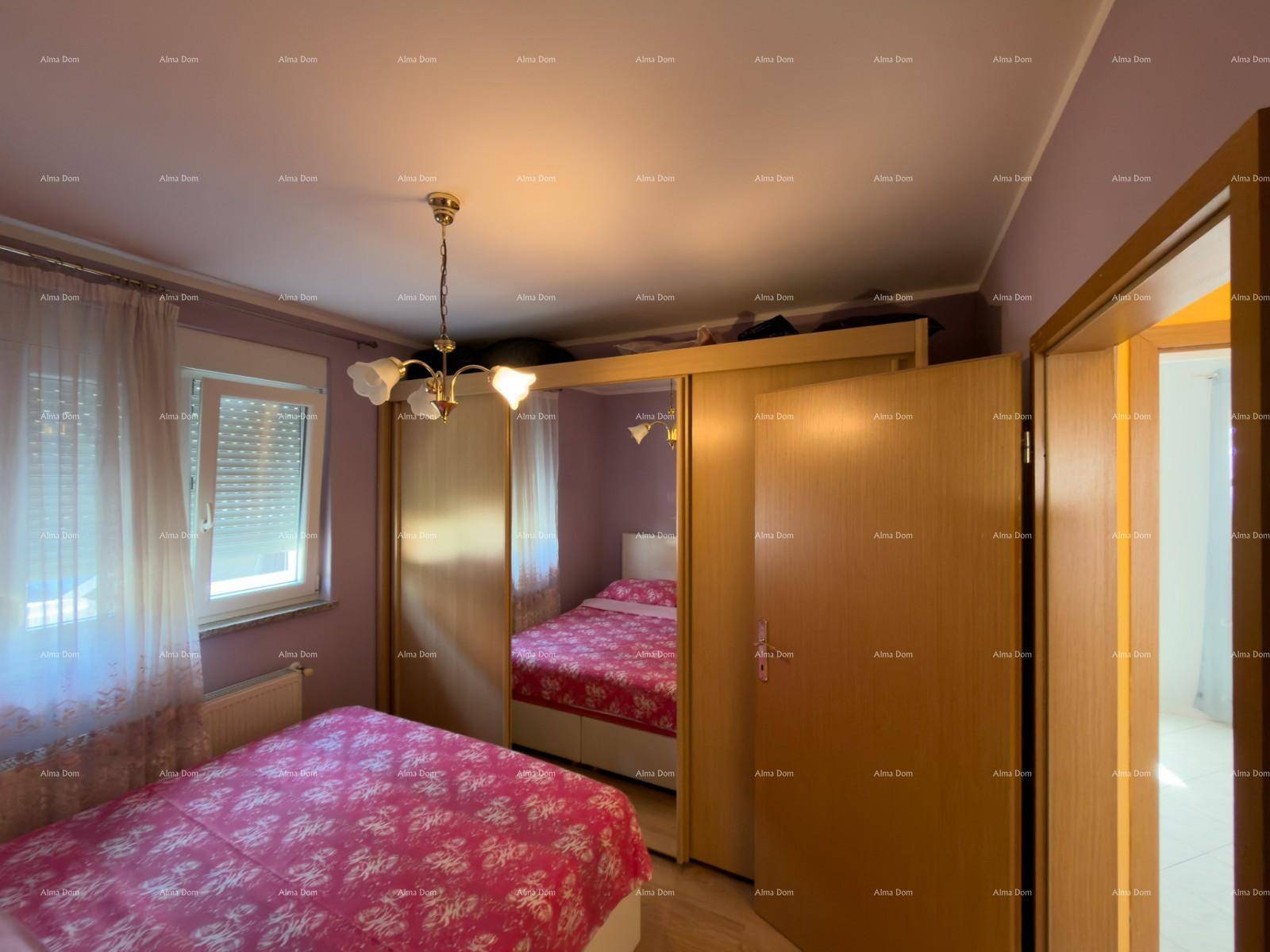Gemütliches Schlafzimmer mit Doppelbett, rosa Bettwäsche und großem Kleiderschrank.