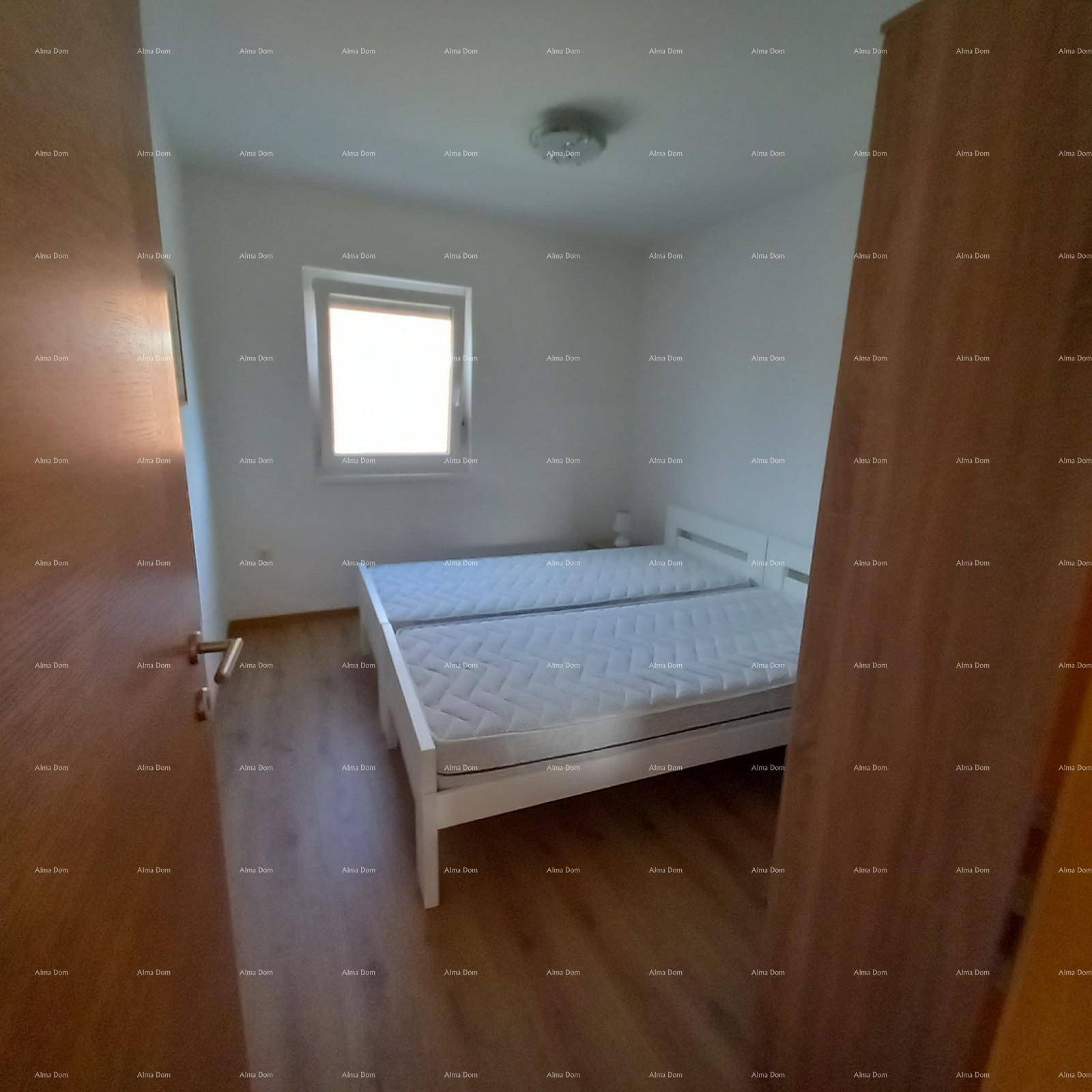 Schlafzimmer mit zwei Einzelbetten, Holzfußboden und einem Fenster für ausreichend Tageslicht.