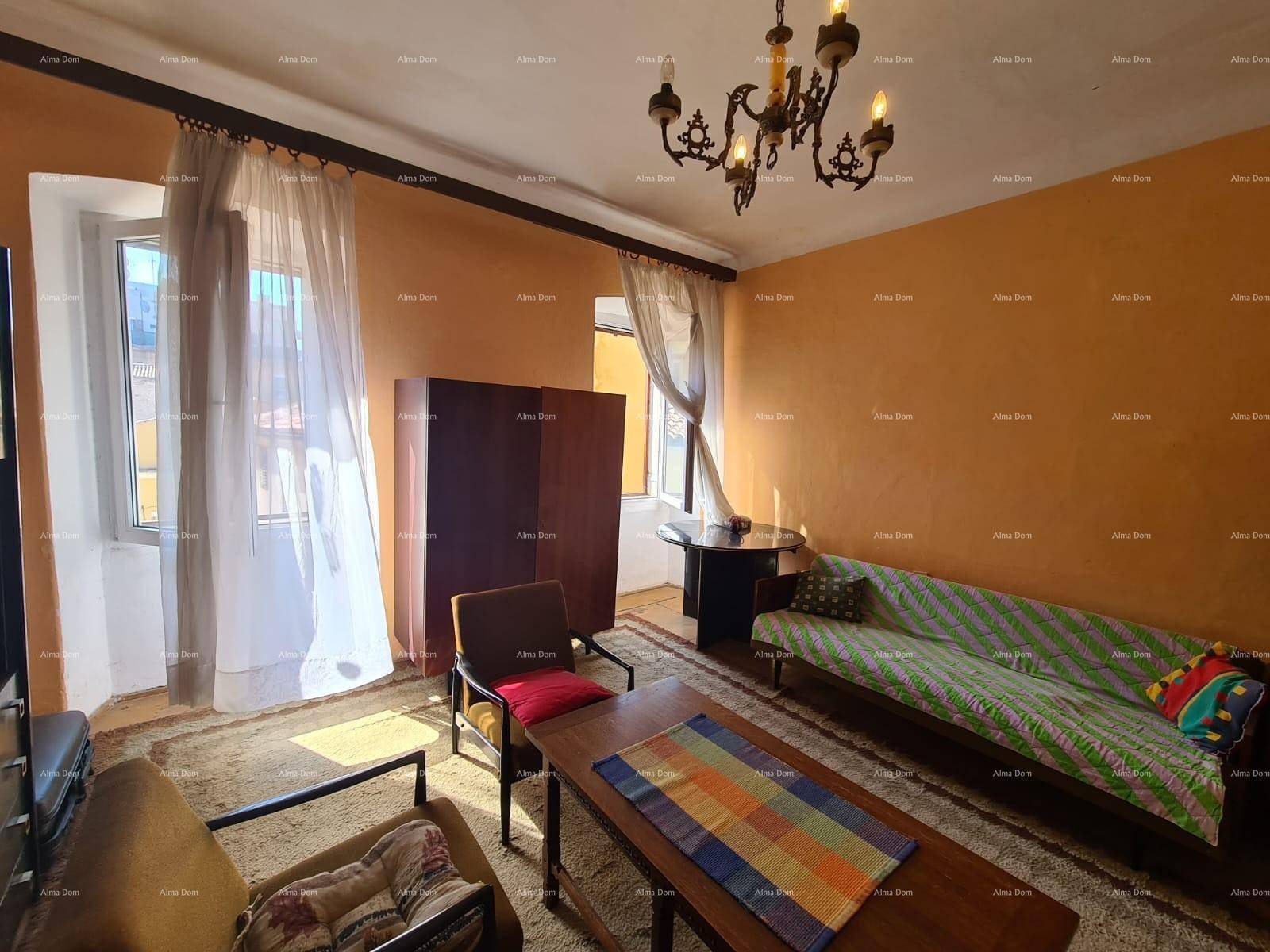 Gemütliches Wohnzimmer mit orangefarbenen Wänden, Teppichboden und einem klassischen Kronleuchter.