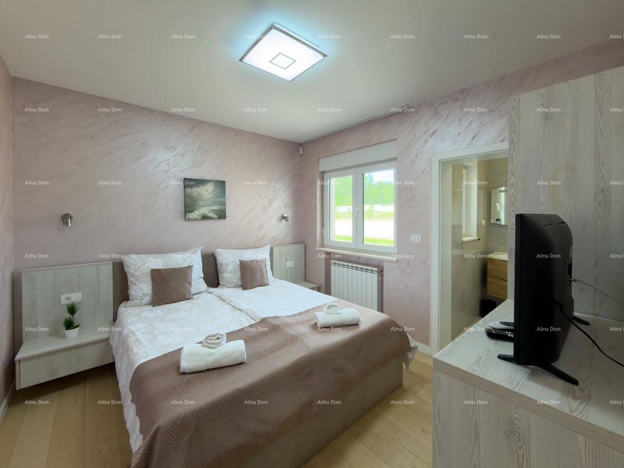 Schlafzimmer mit Doppelbett, Fenster und direktem Zugang zum Badezimmer.