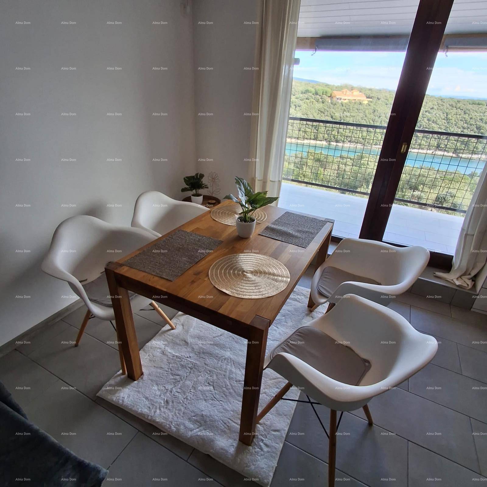 Heller Essbereich mit Holztisch, modernen Stühlen und weitem Blick ins Grüne und auf das Meer.
