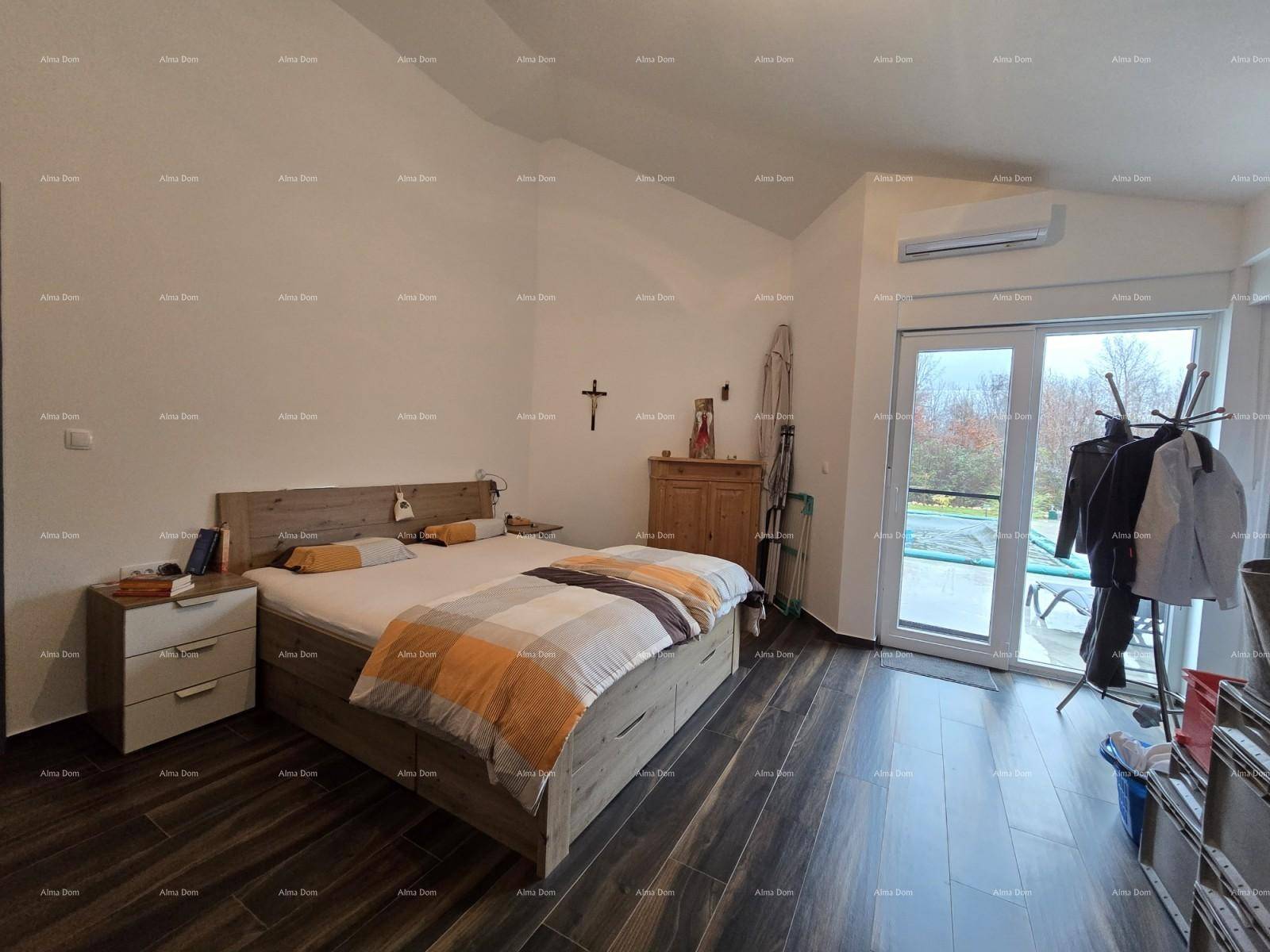 Schlafzimmer mit Doppelbett, großem Kleiderschrank und Zugang zur Terrasse.