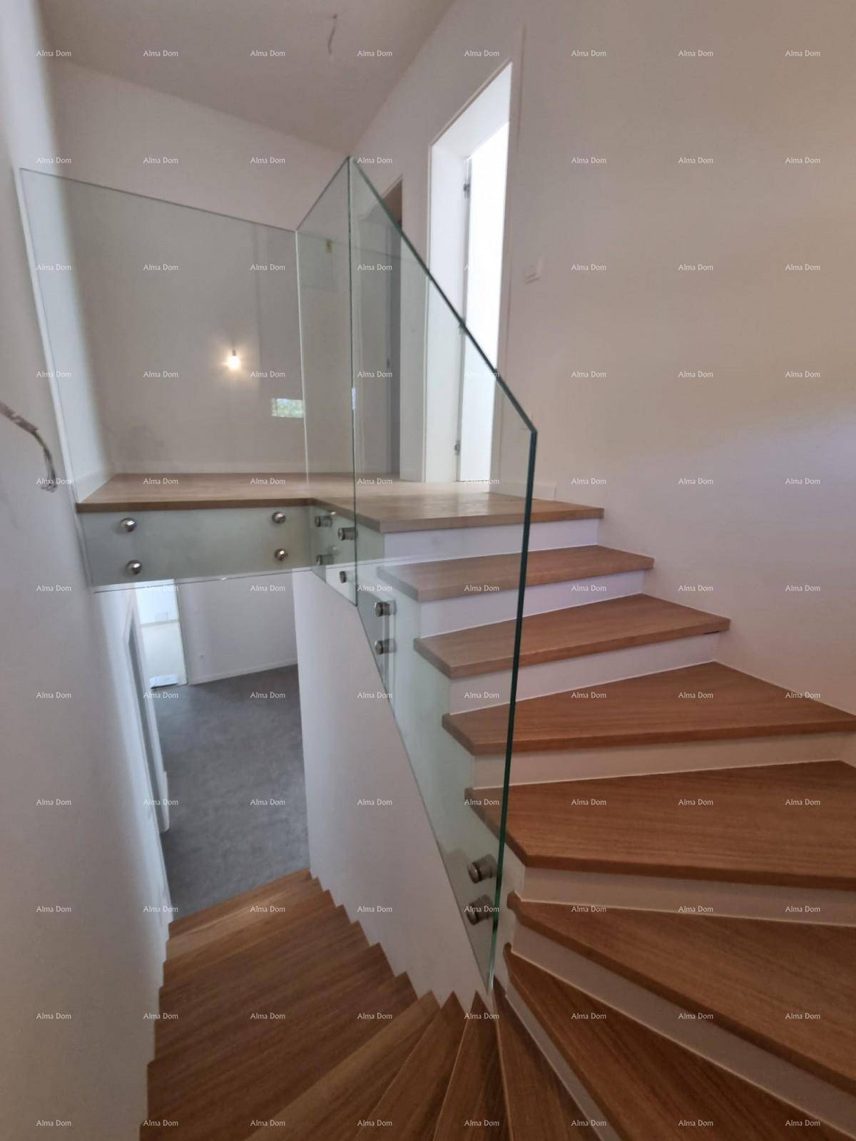 Treppenabsatz mit Glasgeländer und Blick auf die darunterliegende Etage.