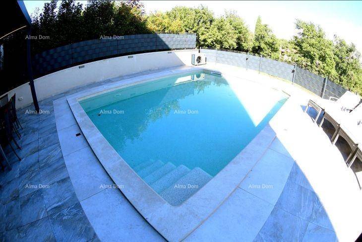 Großer Swimmingpool mit gefliestem Randbereich und sonniger Terrasse.