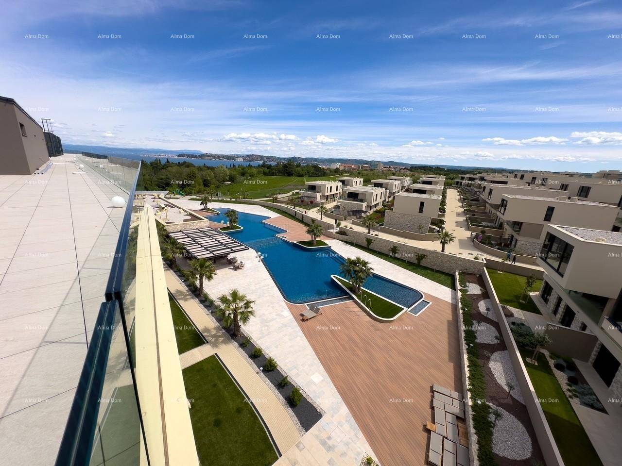 Panoramablick auf eine moderne Wohnanlage mit weitläufigem Poolbereich, umgeben von grüner Landschaft und Meerblick.