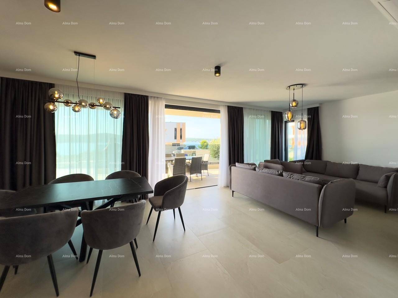 Offener Wohn- und Essbereich mit modernem Esstisch, bequemen Sofas und Zugang zur Terrasse mit Meerblick.