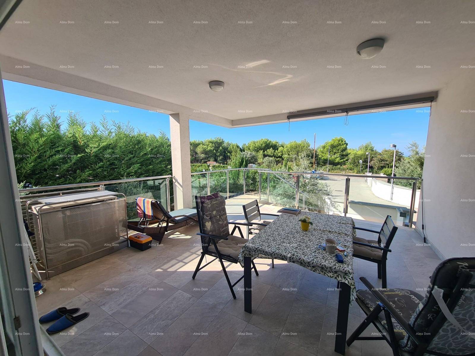 Große, sonnige Terrasse mit Esstisch, Liegestuhl und weitem Blick ins Grüne.