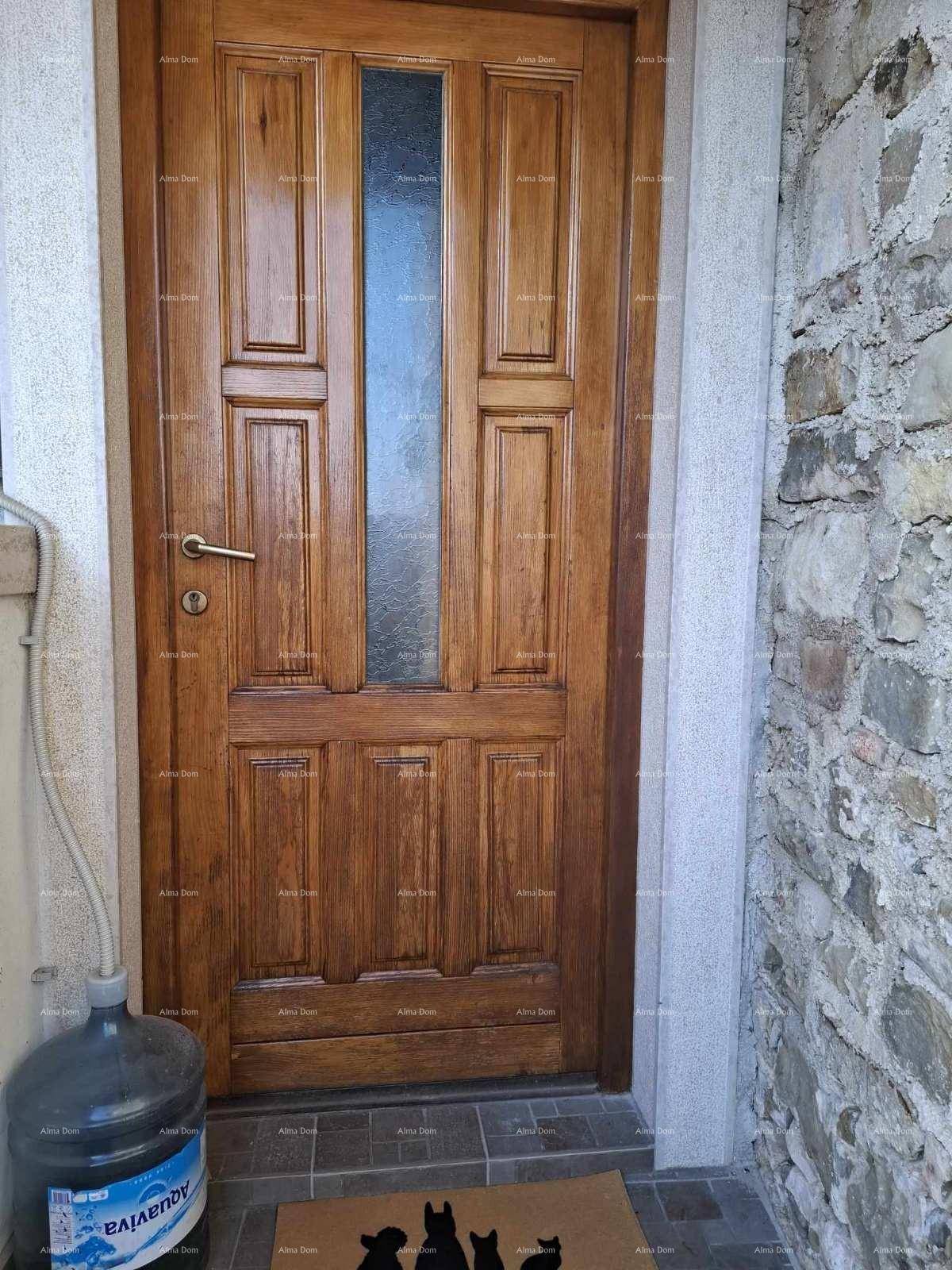 Holzeingangstür mit Glaseinsatz und Fliesenboden im Eingangsbereich des Hauses.