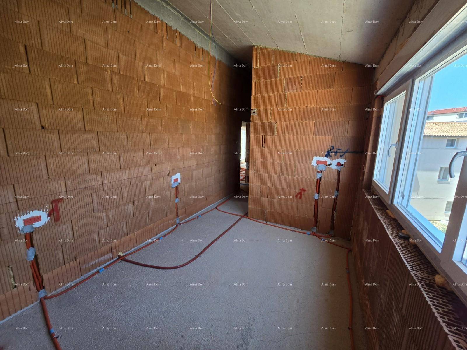 Innenraum im Rohbau mit Ziegelwänden, Betondecke und Dachschräge.