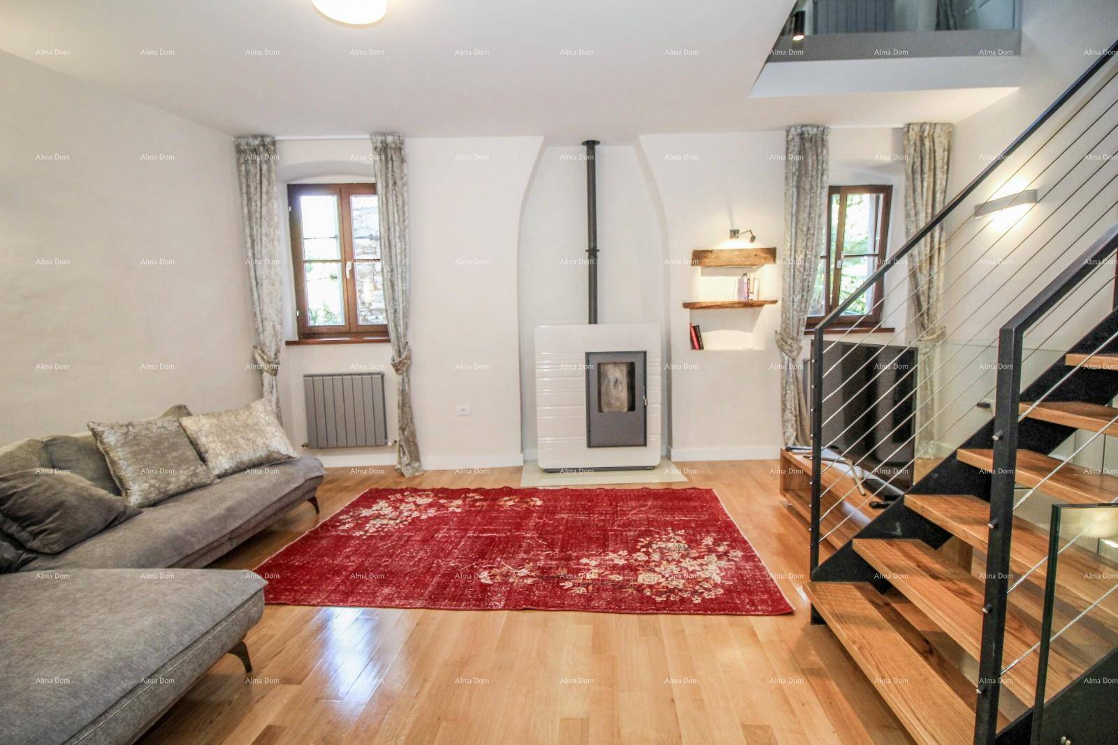 Gemütliches Wohnzimmer mit Holzboden, modernem Kaminofen und offener Treppe zu den oberen Etagen.