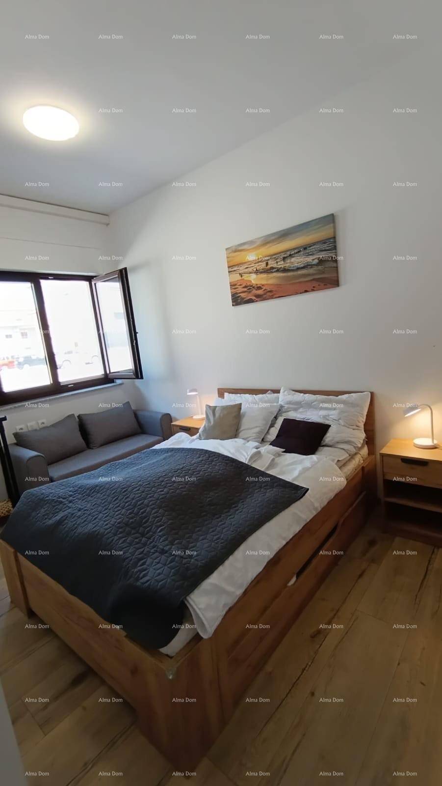 Schlafzimmer mit Doppelbett, kleinem Sofa und Fenster für natürliches Licht.