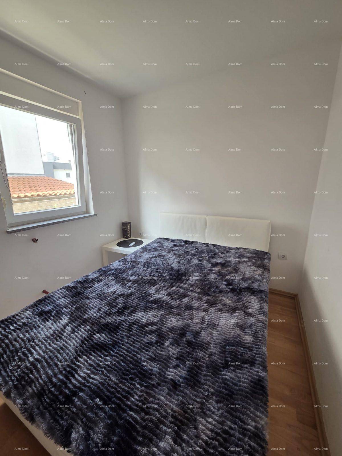 Helles Schlafzimmer mit Doppelbett, Holzboden und einem Fenster, das viel Licht hereinlässt.