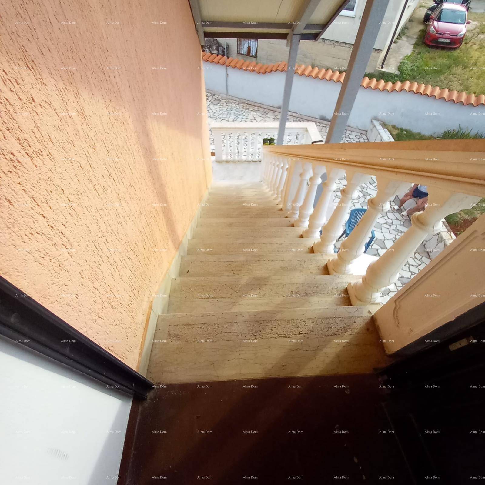 Außentreppe mit Balustrade, die zum Eingang des Gebäudes führt, umgeben von einer beigen Wand.