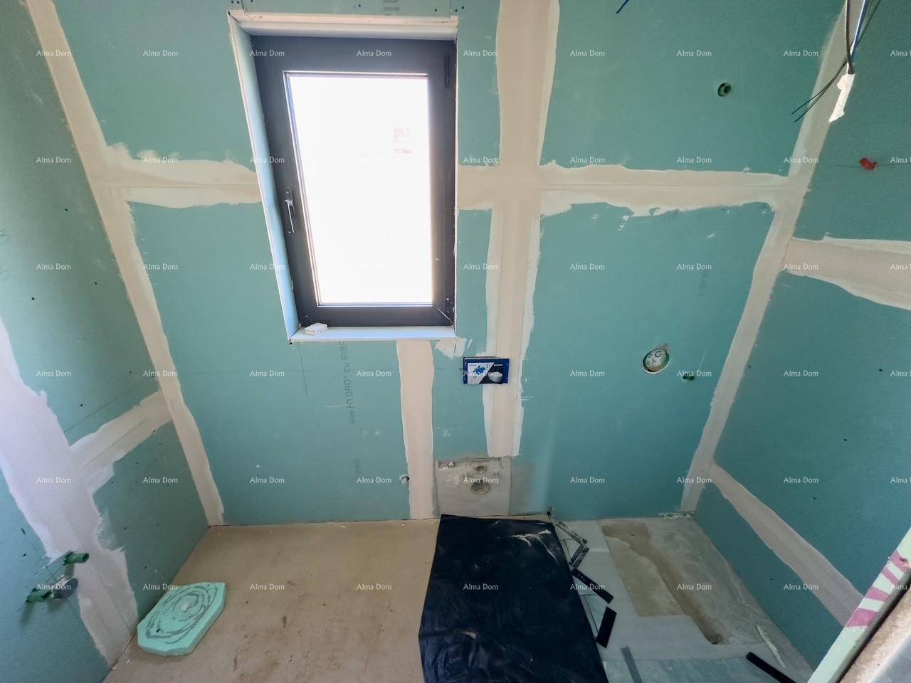 Rohbau-Badezimmer mit blauen Trockenbauwänden, Fenster und sichtbaren Bodeninstallationen für die Dusche oder Badewanne.