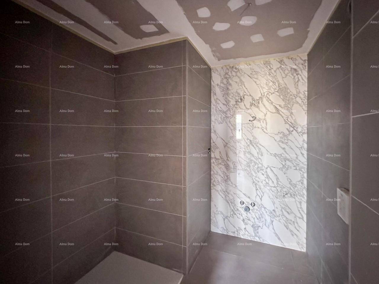 Unfertiges Badezimmer mit grauen Fliesen und einer Marmorwand in der Duschkabine.
