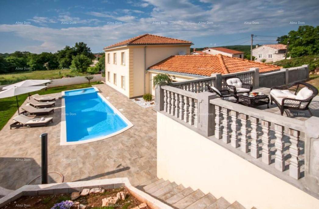 Gesamtansicht der Villa mit großem Poolbereich, Terrasse und weitläufigem Garten unter blauem Himmel.