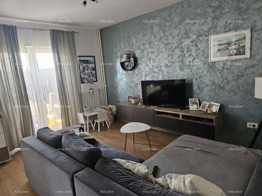 Helles Wohnzimmer mit Zugang zum Balkon, türkiser Akzentwand und gemütlichem Sofa.