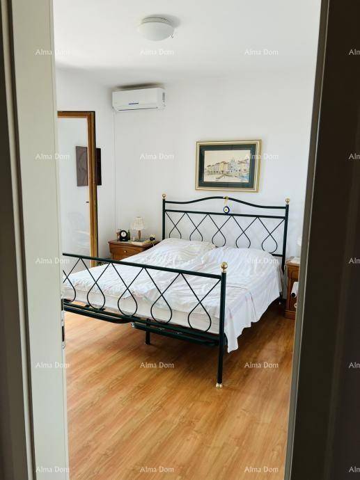 Helles Schlafzimmer mit Holzboden, schmiedeeisernem Bett und Klimaanlage für angenehmen Komfort.