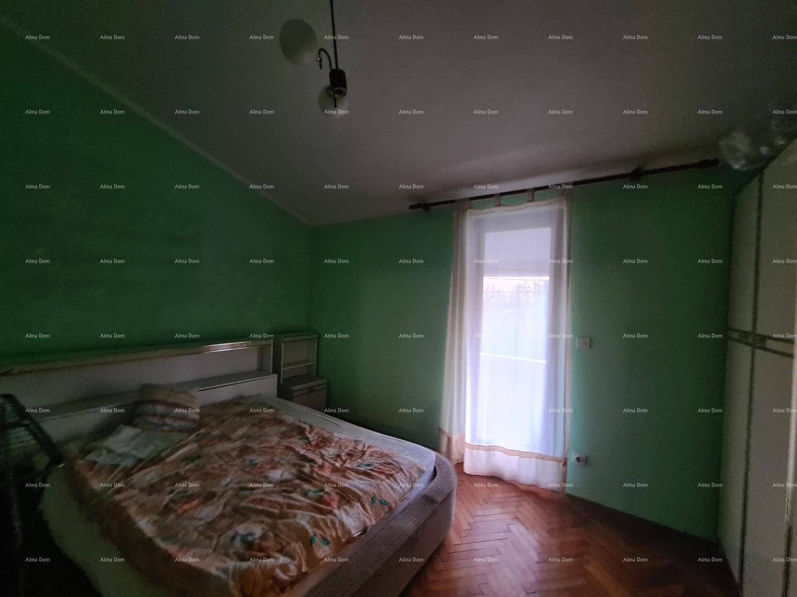 Schlafzimmer mit grünen Wänden, einem Doppelbett und einem Fenster für natürliches Licht.