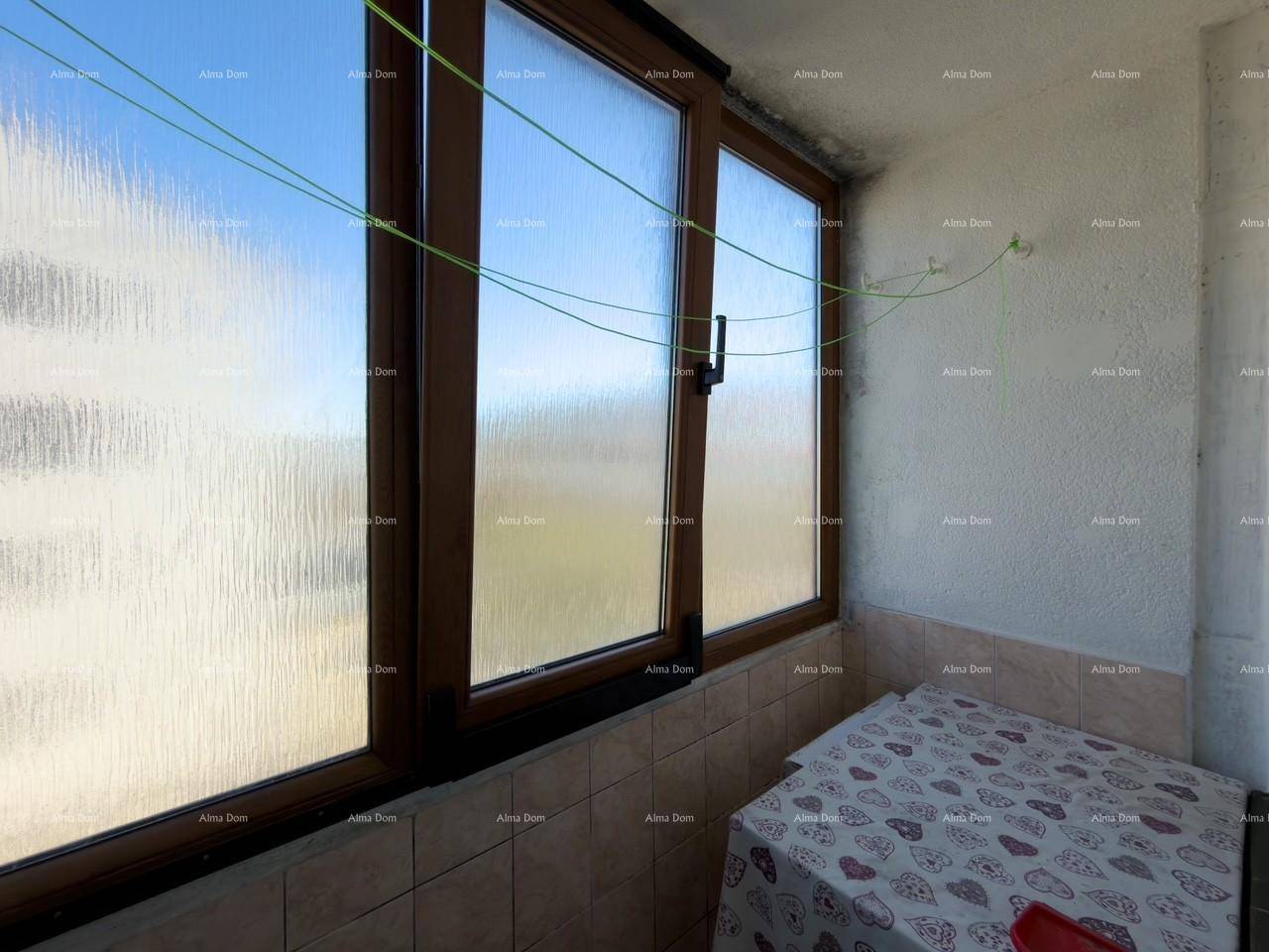 Verglaste Loggia mit Fensterfront und Fliesenboden, ideal als Abstellraum.