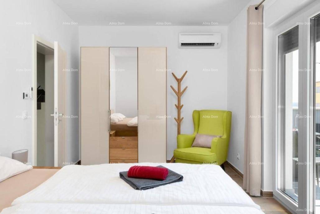 Schlafzimmer mit Bett, Kleiderschrank, grünem Sessel und Klimaanlage.