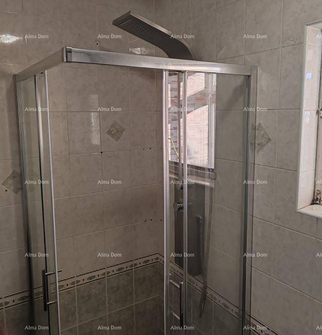 Moderne Duschkabine im Badezimmer mit Fliesenwänden und einem Regenduschkopf.
