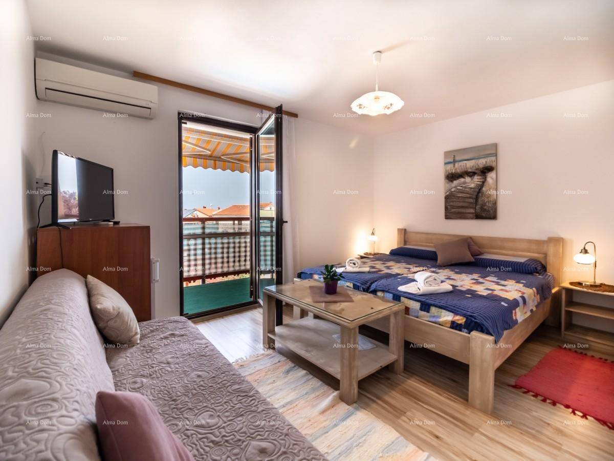 Gemütliches Schlafzimmer mit zwei Einzelbetten, Sofa, Klimaanlage und Zugang zum Balkon.