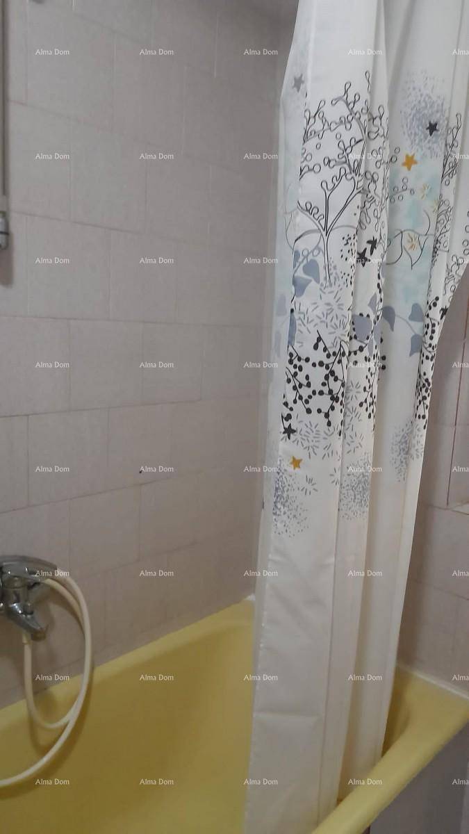 Badezimmer mit einer gelben Badewanne und Duschvorhang, umgeben von hellen Fliesen.