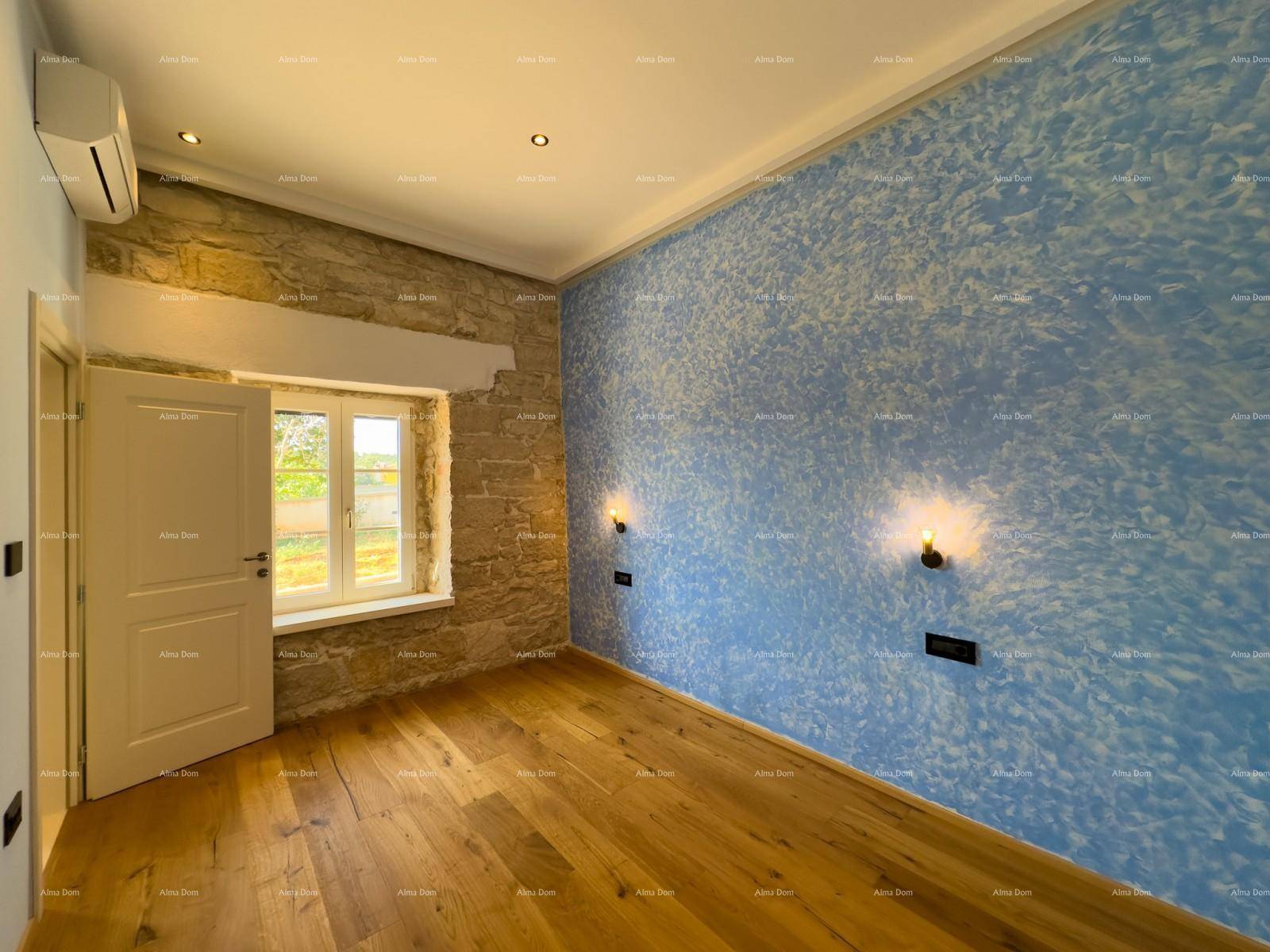 Schlafzimmer mit blauer Wand, freiliegender Steinwand und Fenster mit Blick ins Grüne.