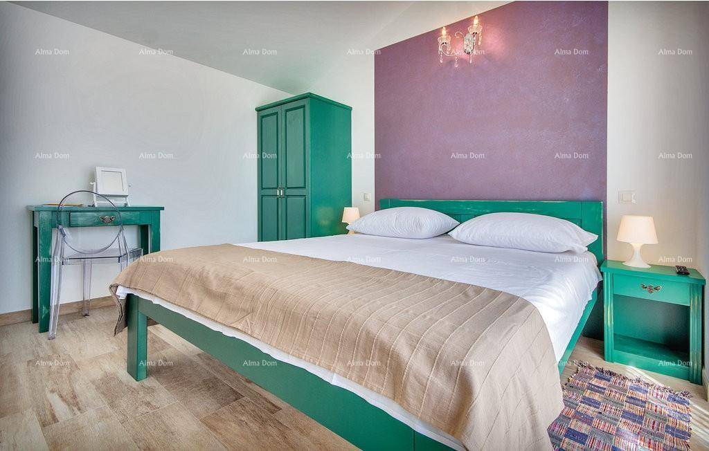 Schlafzimmer mit grünen Möbeln, violetter Akzentwand und hellem Ambiente.