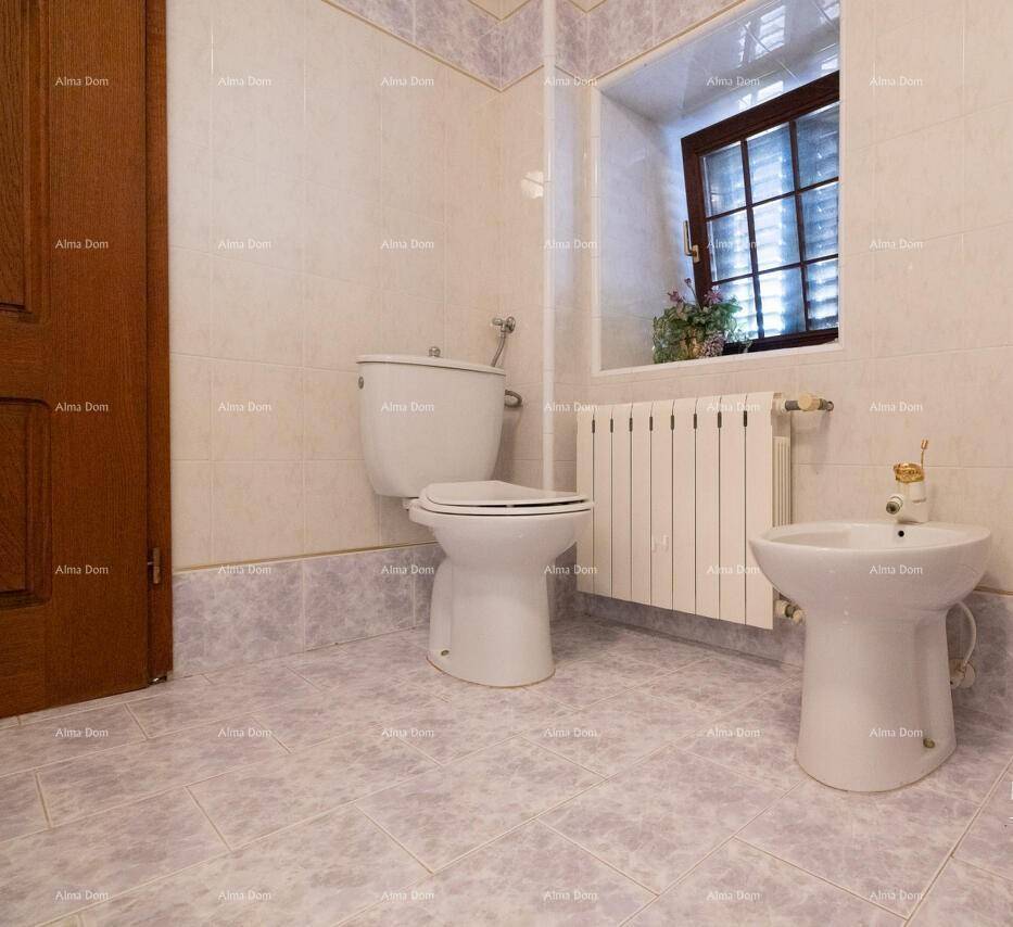 Badezimmer mit WC, Bidet und einem Fenster für natürliche Belüftung.