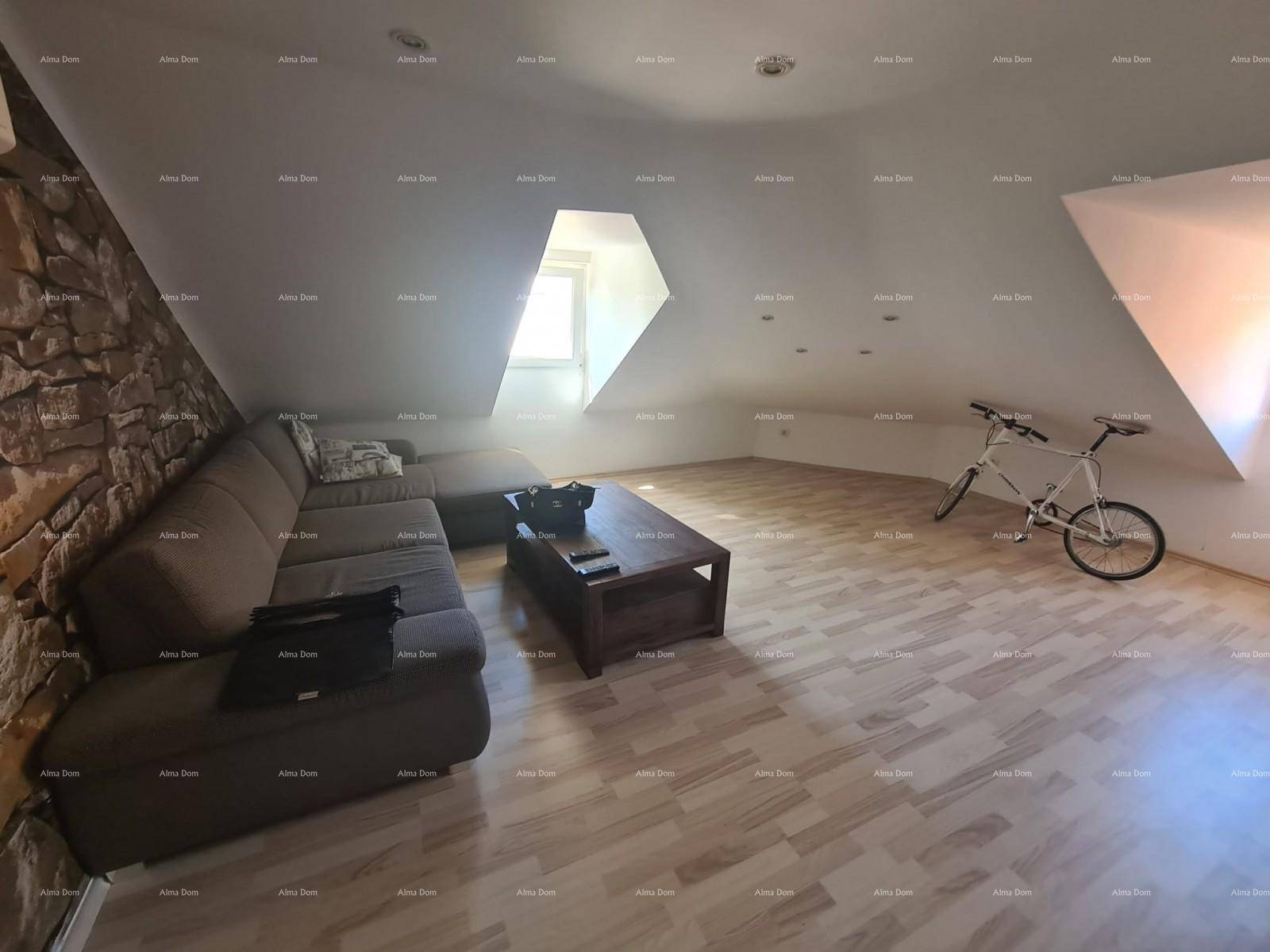 Geräumiges Wohnzimmer im Dachgeschoss mit großer Eckcouch, Couchtisch und dekorativer Steinwand.
