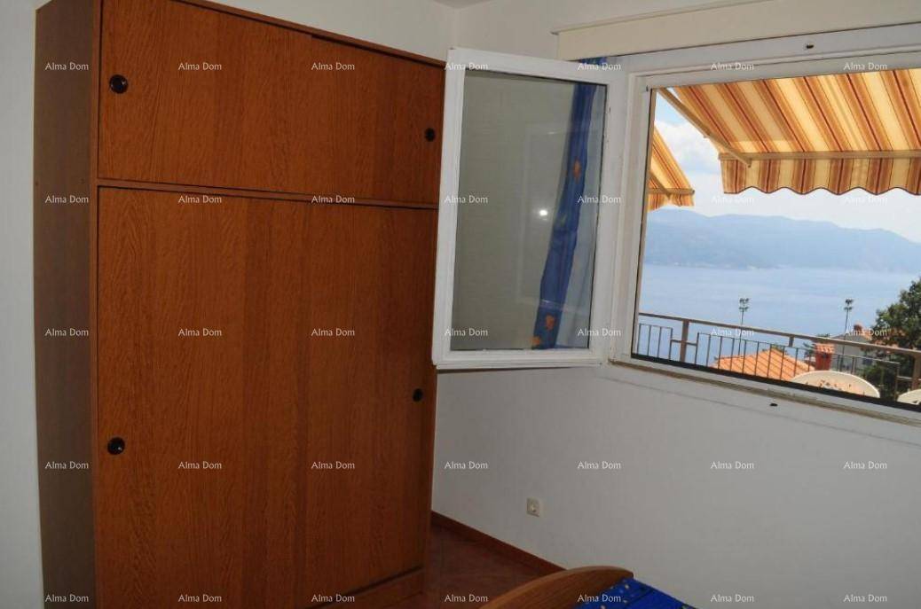 Schlafzimmer mit Holzschrank und Fenster, das einen schönen Meerblick bietet.
