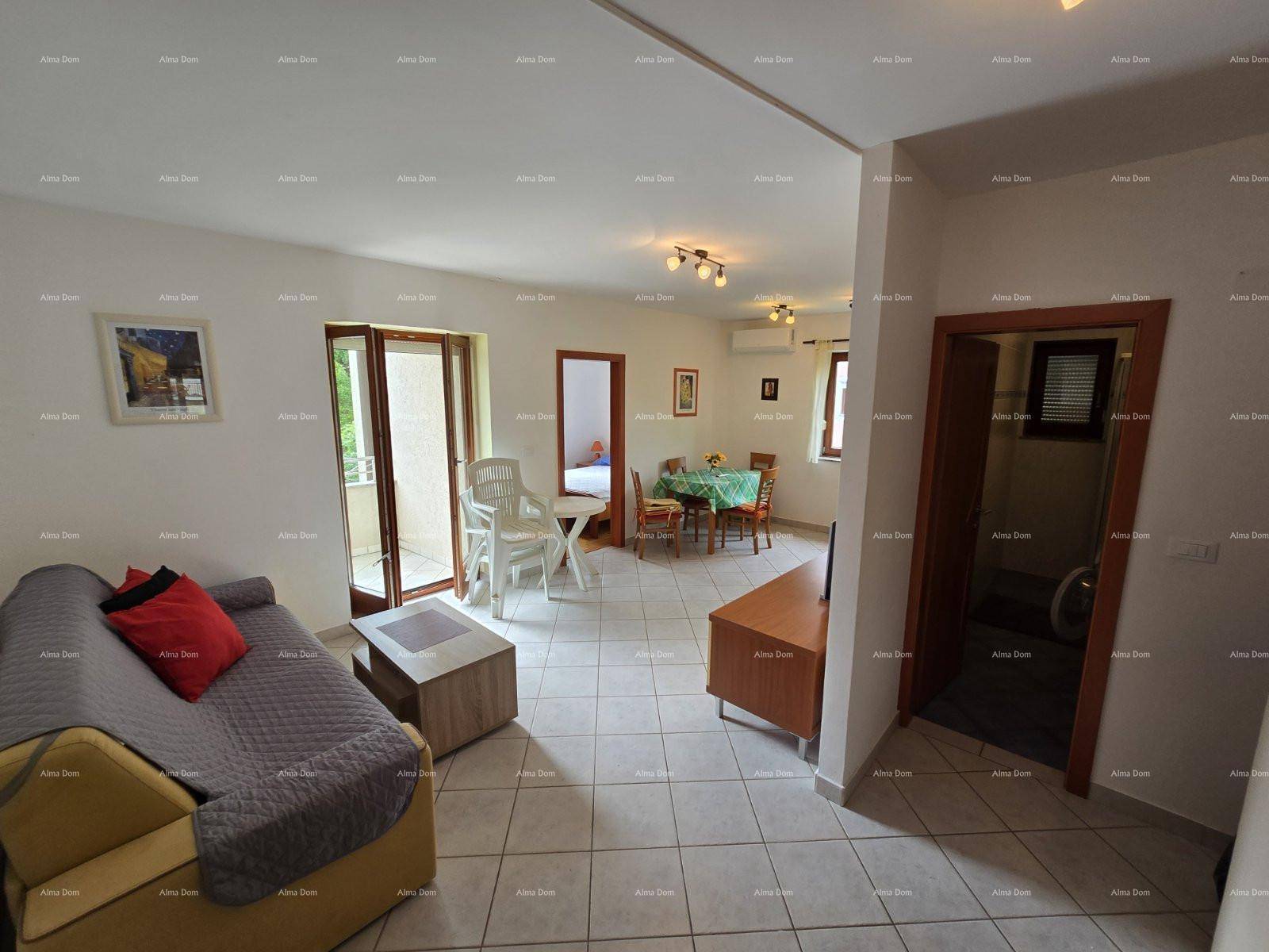 Geräumiger Wohn-Essbereich mit bequemer Couch, Esstisch und Zugang zu weiteren Räumen und Balkon.