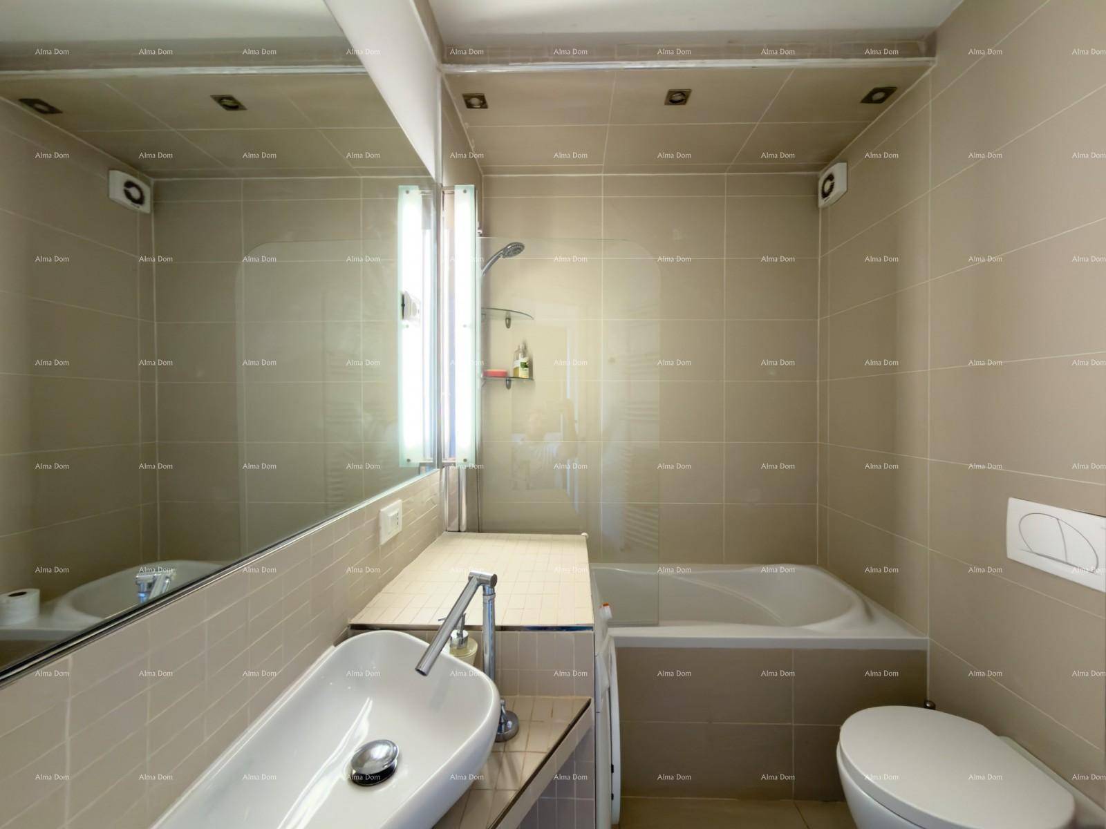 Modernes Badezimmer mit Badewanne, WC und stilvollem Waschbecken auf beigefarbenen Fliesen.