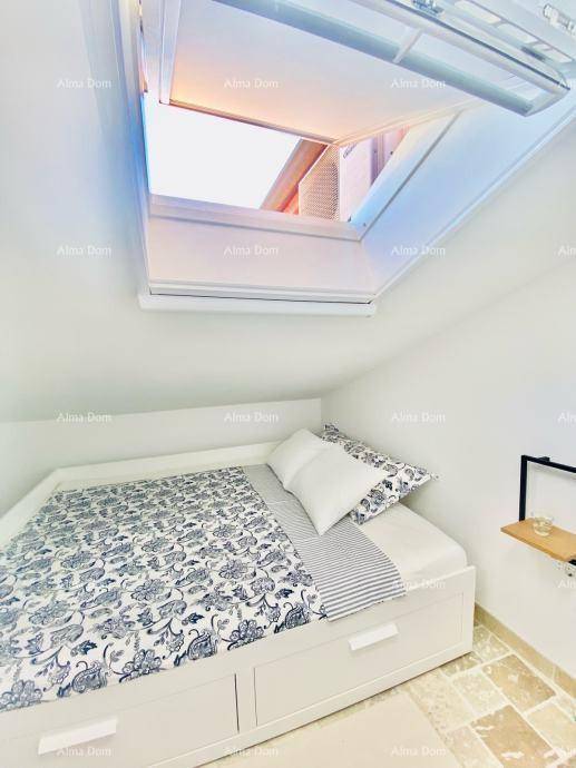 Gemütliches Schlafzimmer mit Einzelbett und großem Dachfenster, das viel Tageslicht hereinlässt.