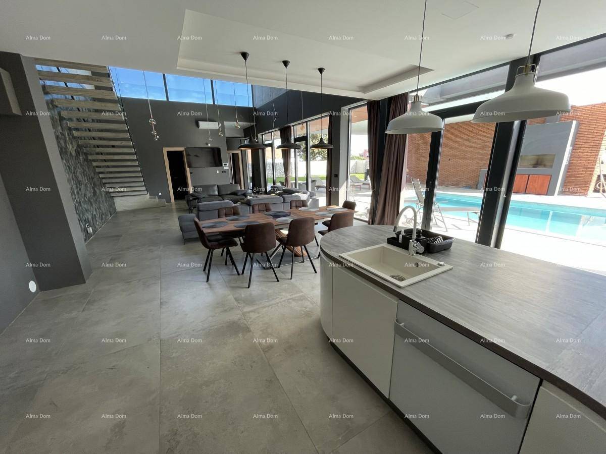 Moderne offene Küche mit Kücheninsel und Blick auf den Essbereich und den Pool im Außenbereich.