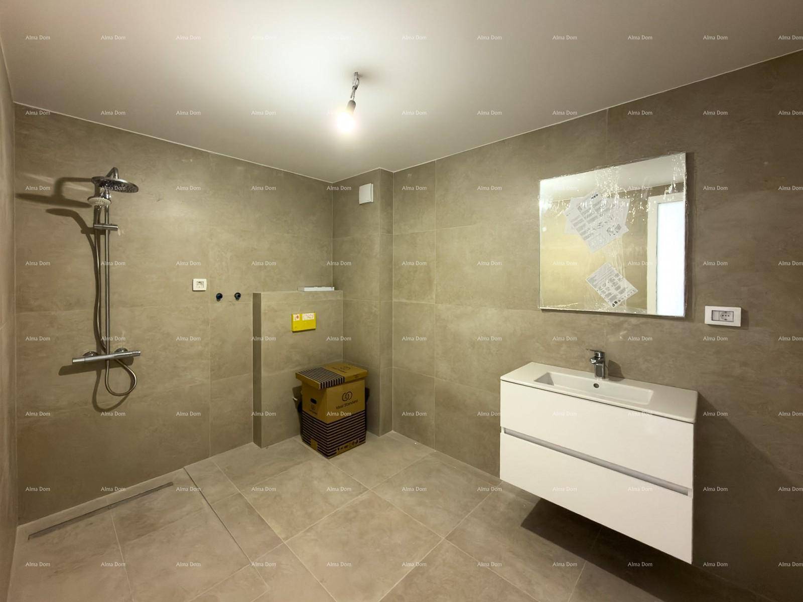 Modernes Badezimmer mit grauen Fliesen, schwebendem Waschtisch und einer geräumigen Duschzone.