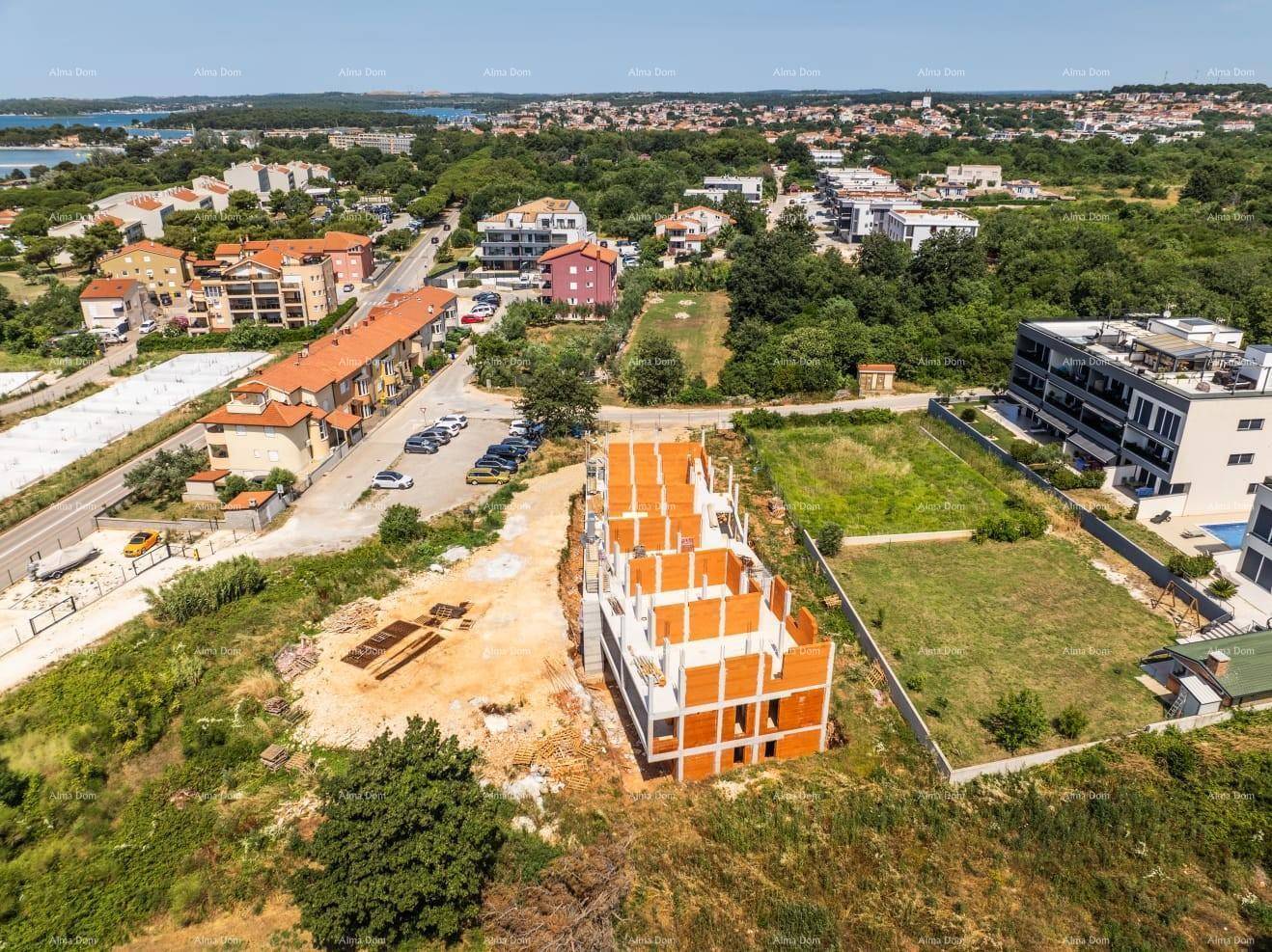Luftaufnahme einer Baustelle, umgeben von viel Grün und bestehenden Wohngebäuden.
