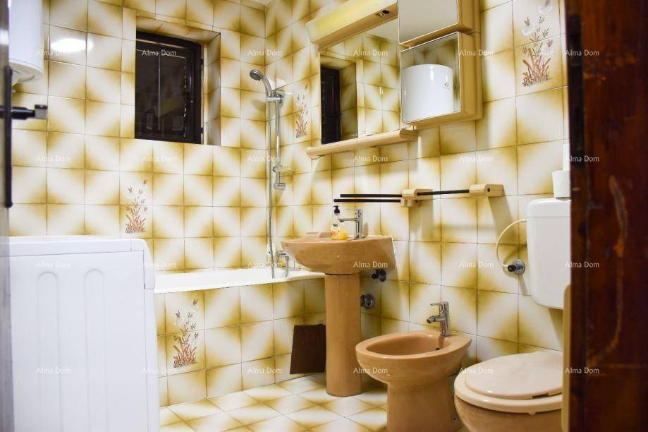 Badezimmer mit gemusterten Fliesen, Waschbecken, Toilette, Bidet und Dusch-Badewannen-Kombination.